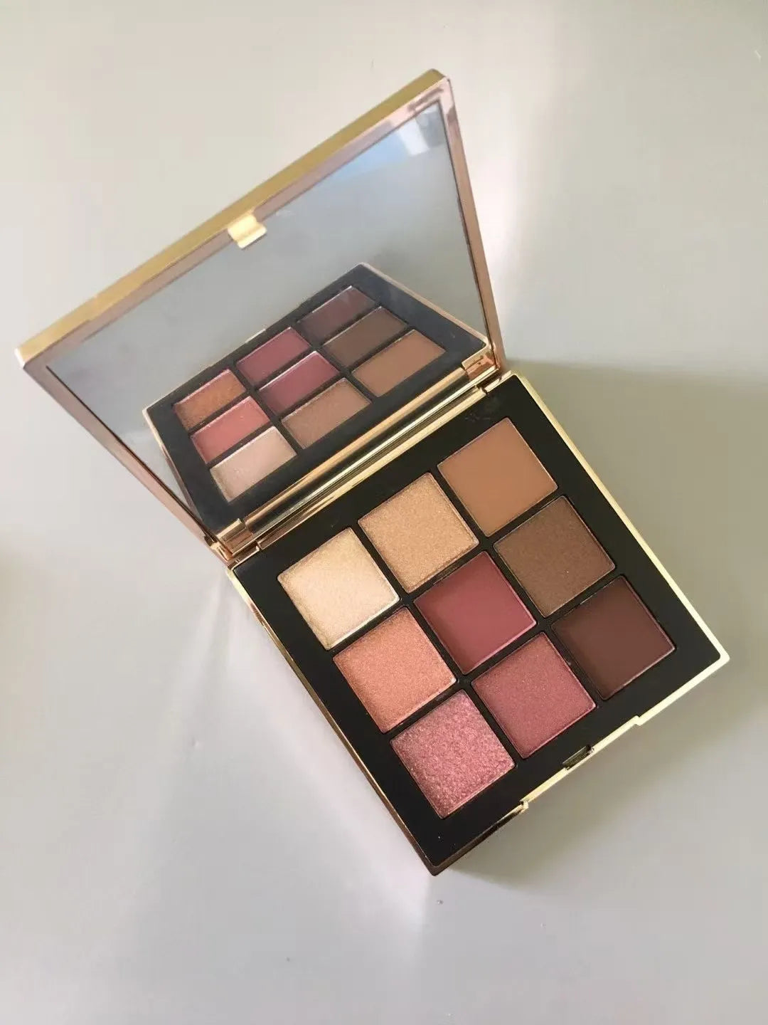 Compact eyeshadow palette open with color swatches displayed