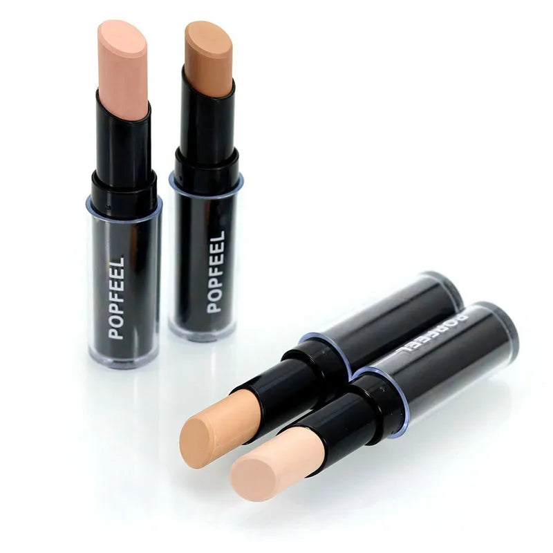 Hand holding concealer stick against skin demonstrating application