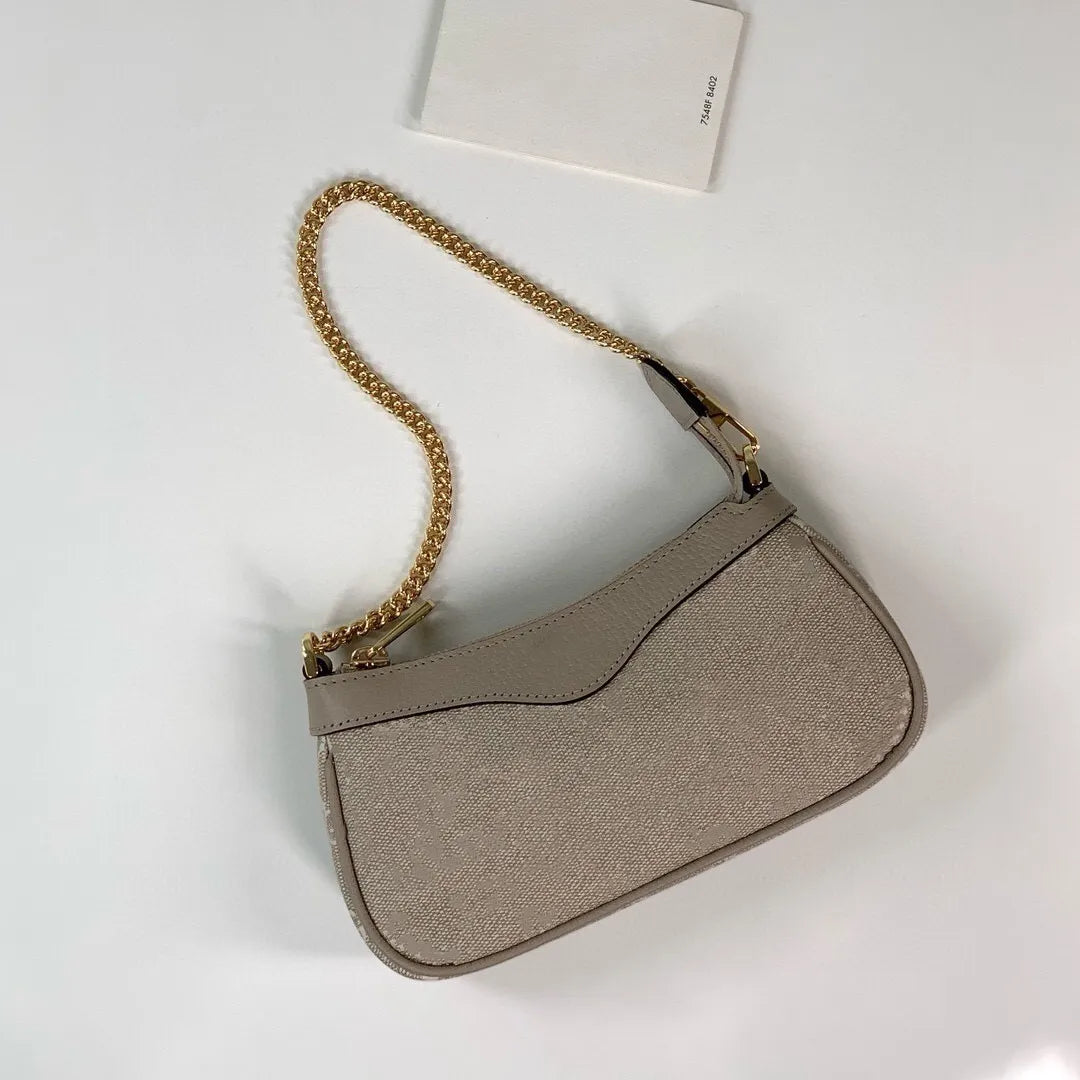 Front view of a small square cosmetic shoulder bag with a structured design