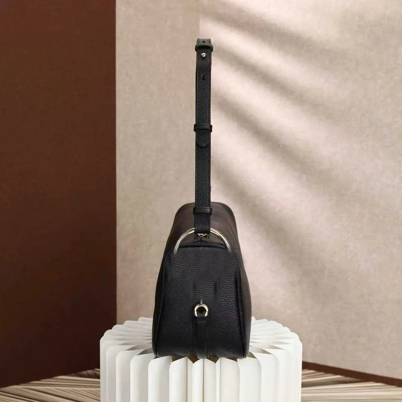 Side view of satchel bag displaying interior compartments and closure