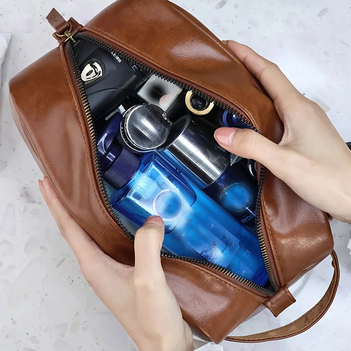Compact travel toiletry pouch in brown color placed next to bathroom items