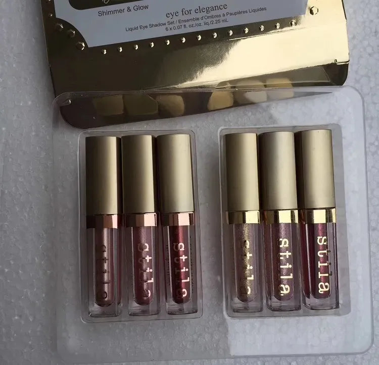 Six liquid eyeshadow shades in earth tones displayed in packaging