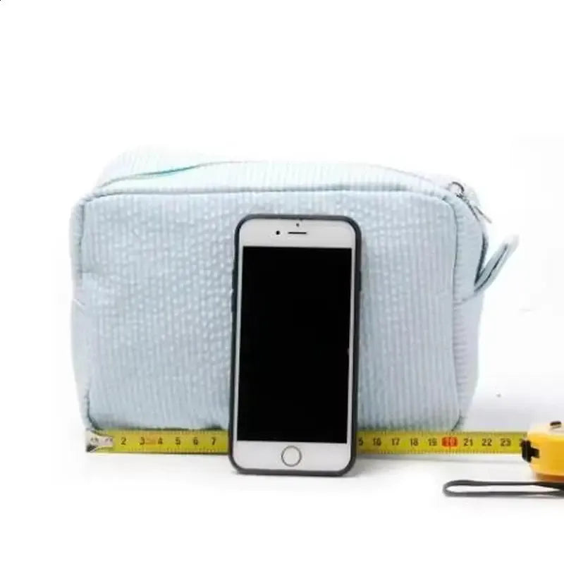 Close-up view of the zipper closure on the striped cosmetic bag
