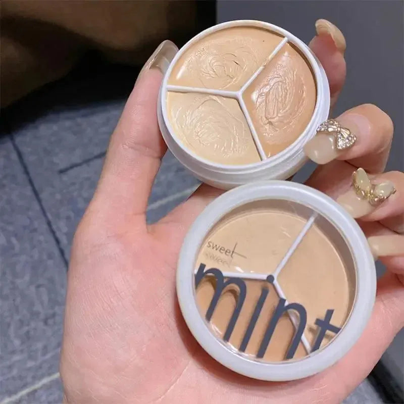 Open palette showing three different shades of concealer in a compact case
