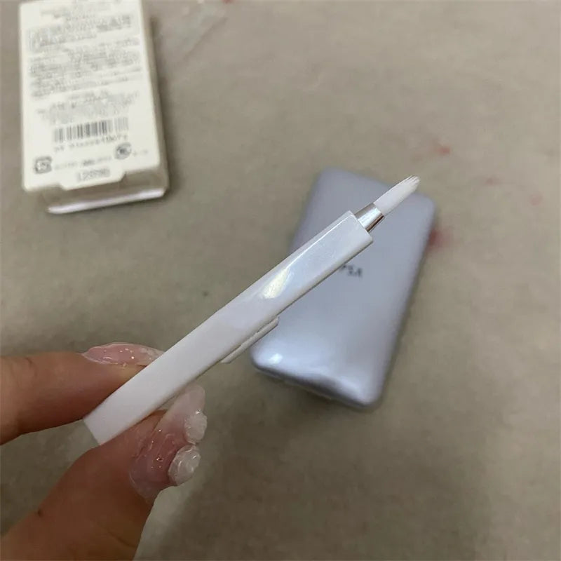 The included brush shown next to the open concealer compact