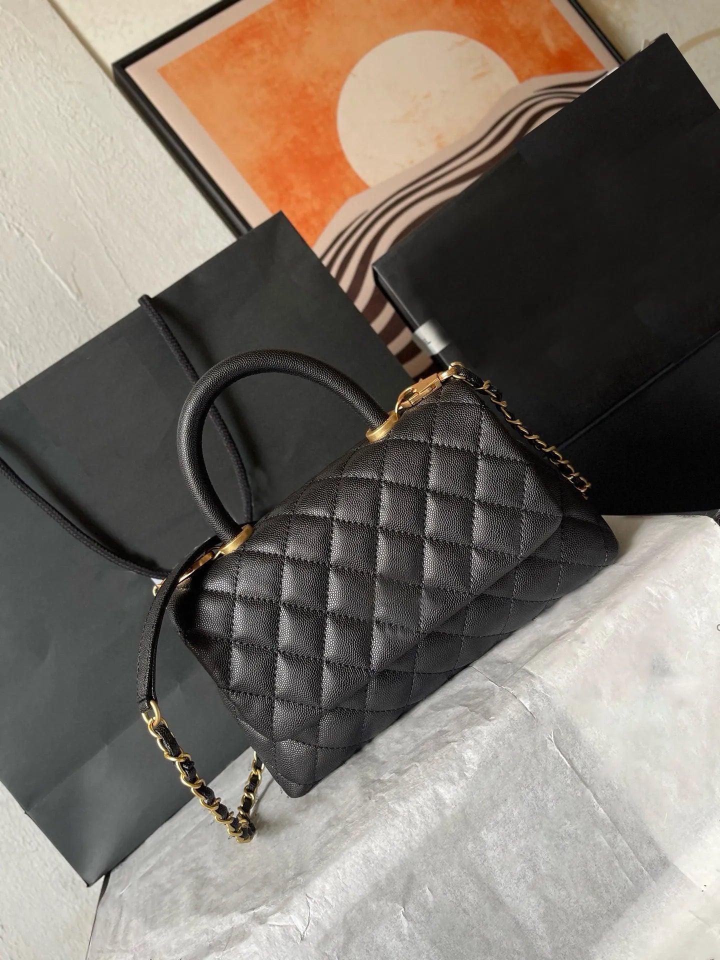 Front view of a women's leather crossbody bag with gold metal flap closure