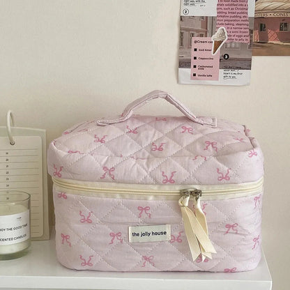 Front view of pink quilted cosmetic bag with bowknot decoration