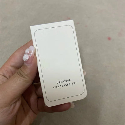 The included brush shown next to the open concealer compact