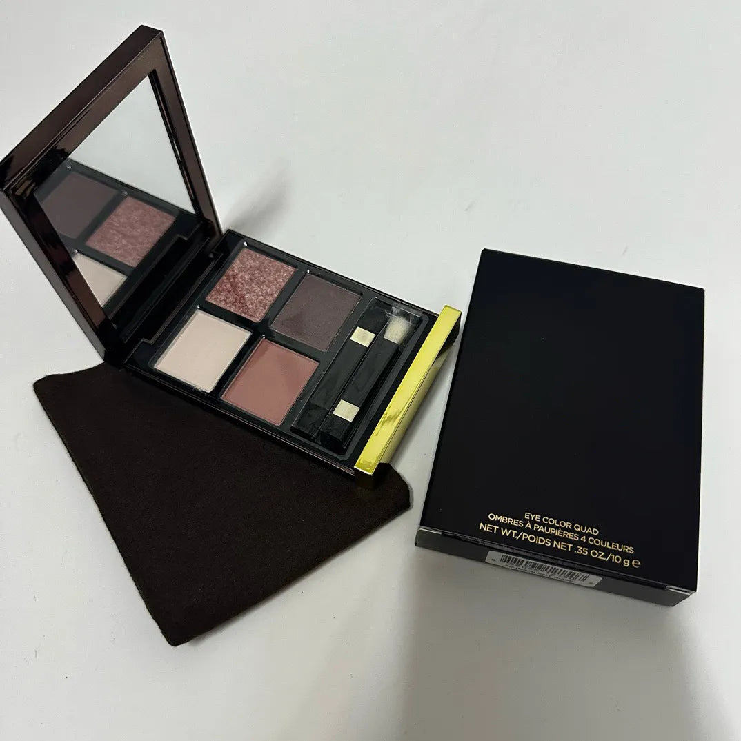 Eyeshadow palette open showing mirror and four color pans