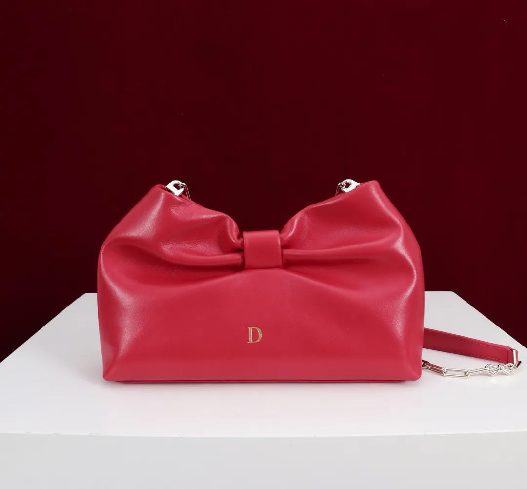Side angle showing structured form and tote handles of evening bag
