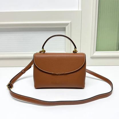 Front view of leather crossbody bag showing baguette shape and strap