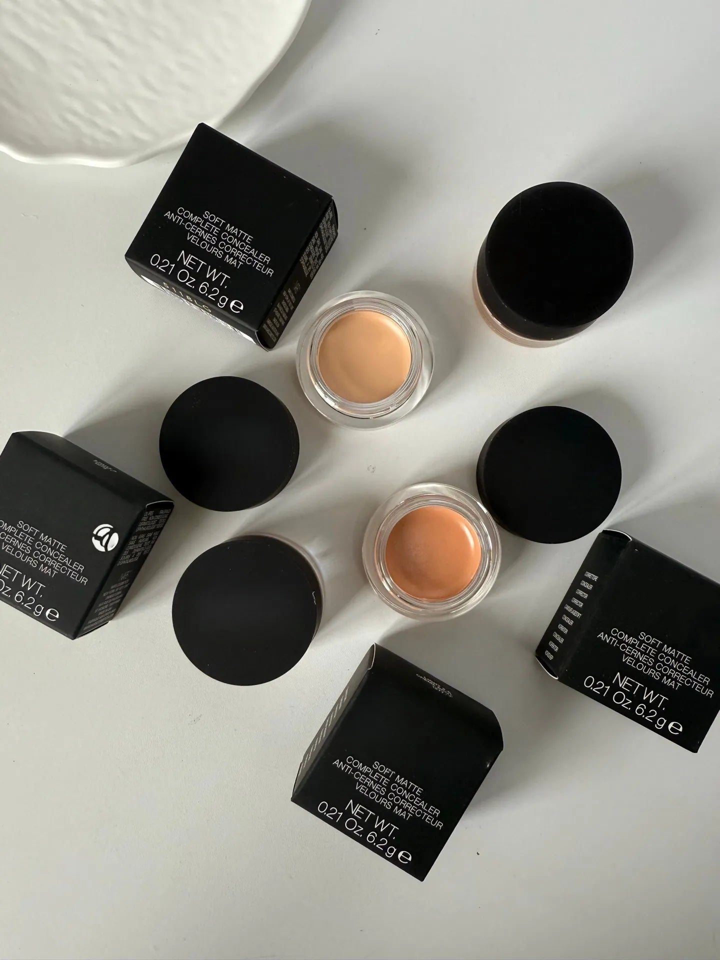 Close-up view of concealer cream being applied to under-eye area