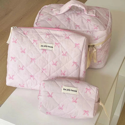 Front view of pink quilted cosmetic bag with bowknot decoration