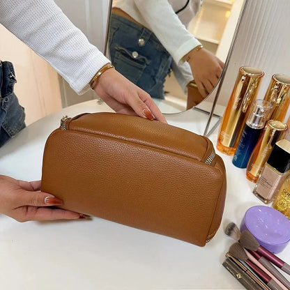 Makeup bag in a neutral color displayed on a flat surface