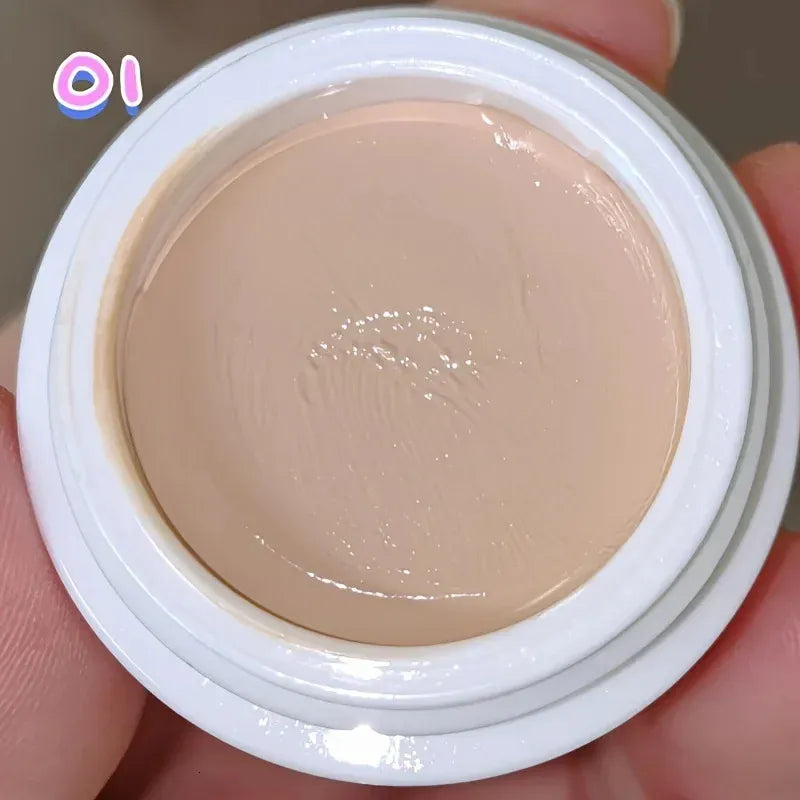 Makeup brush applying concealer from palette to under-eye area