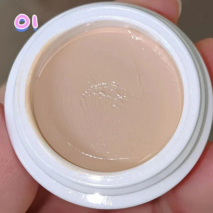 Makeup brush applying concealer from palette to under-eye area