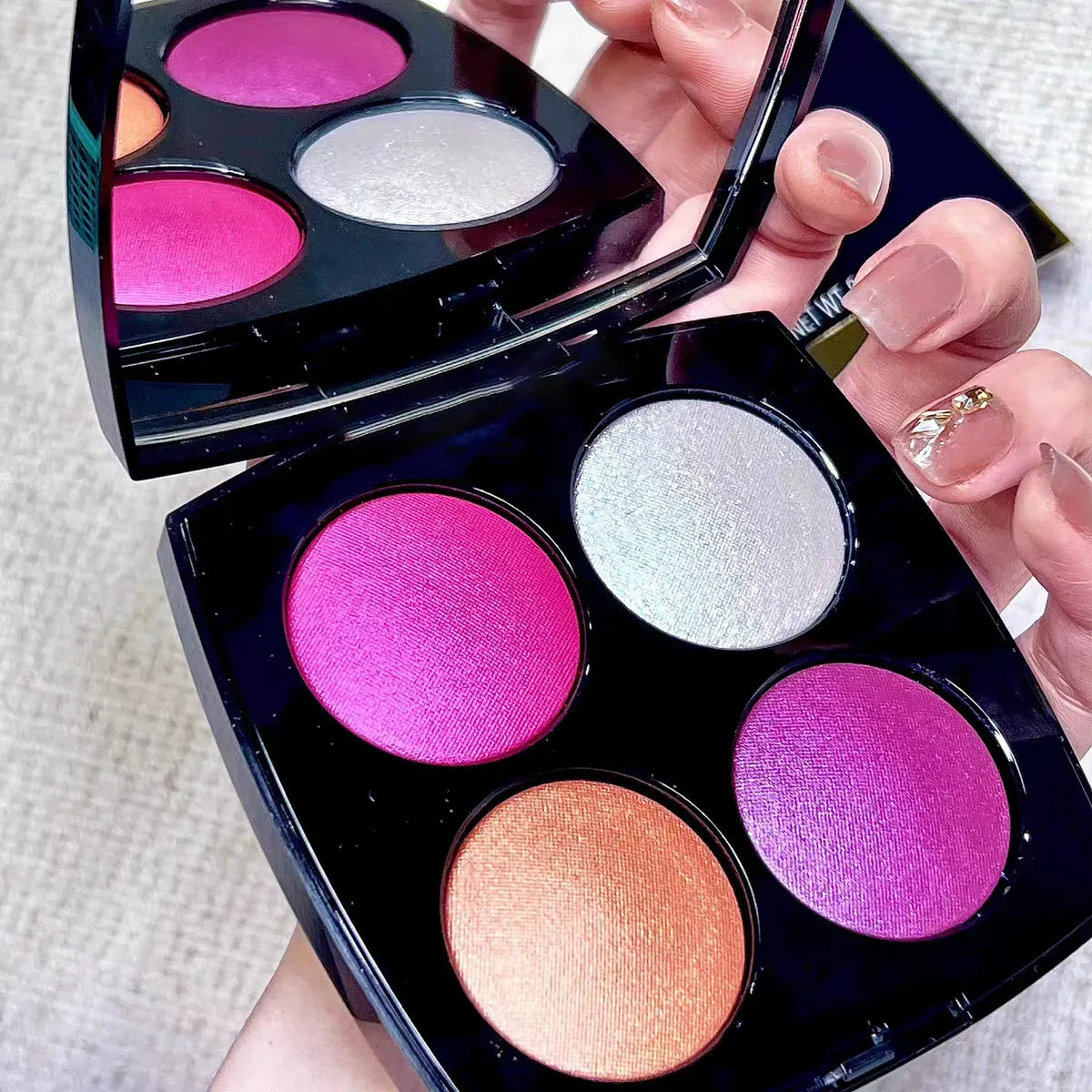 Makeup brush applying color from the palette to demonstrate texture