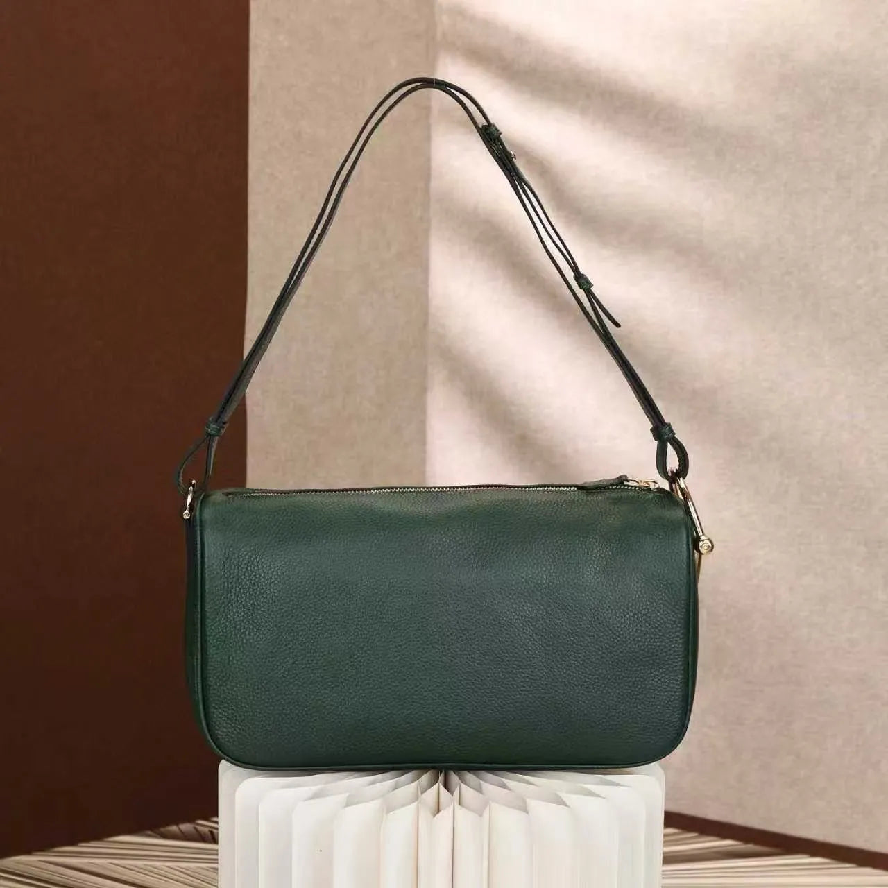 Model wearing shoulder satchel bag demonstrating adjustable strap and size