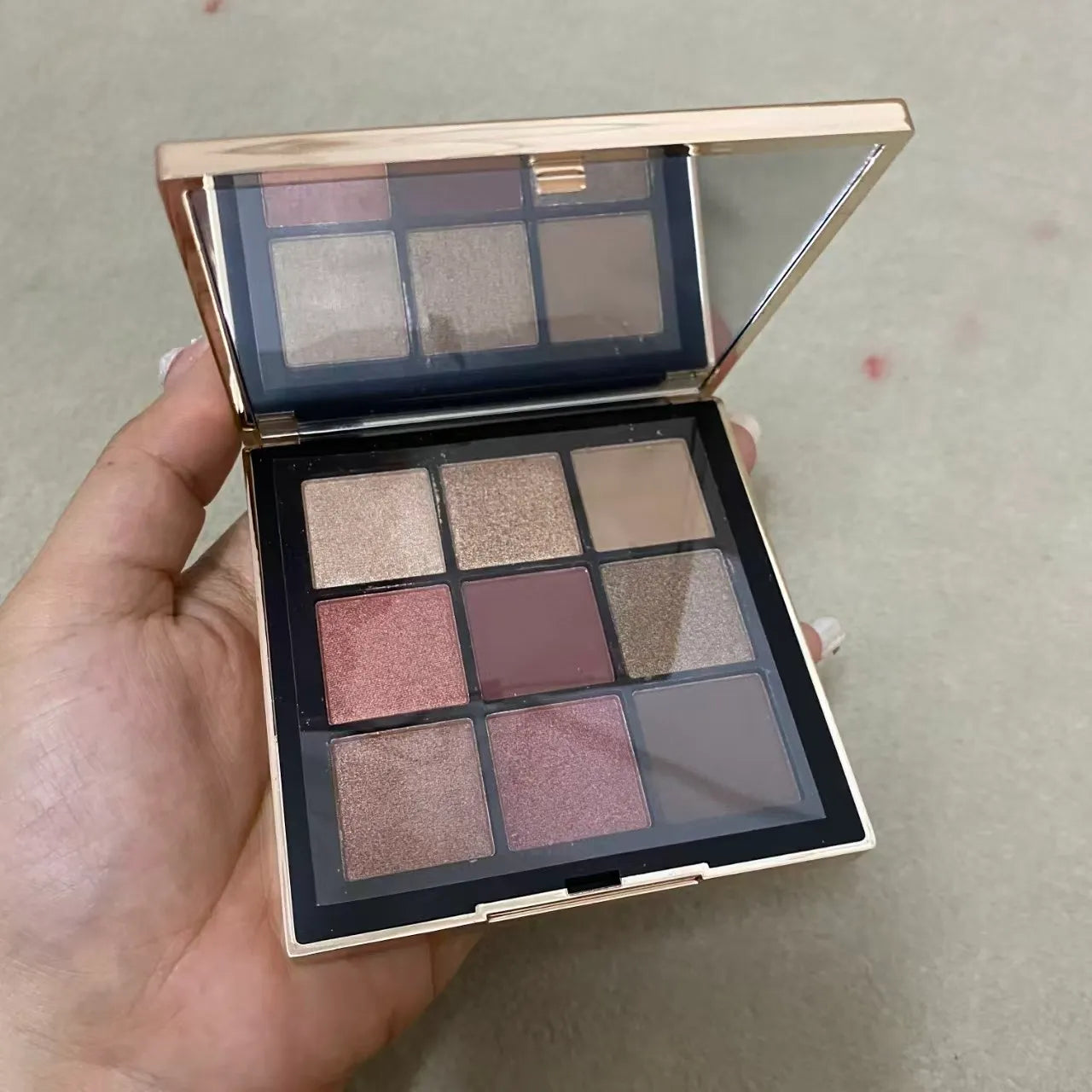 Eyeshadow palette showing nine colors with matte and shimmer finishes