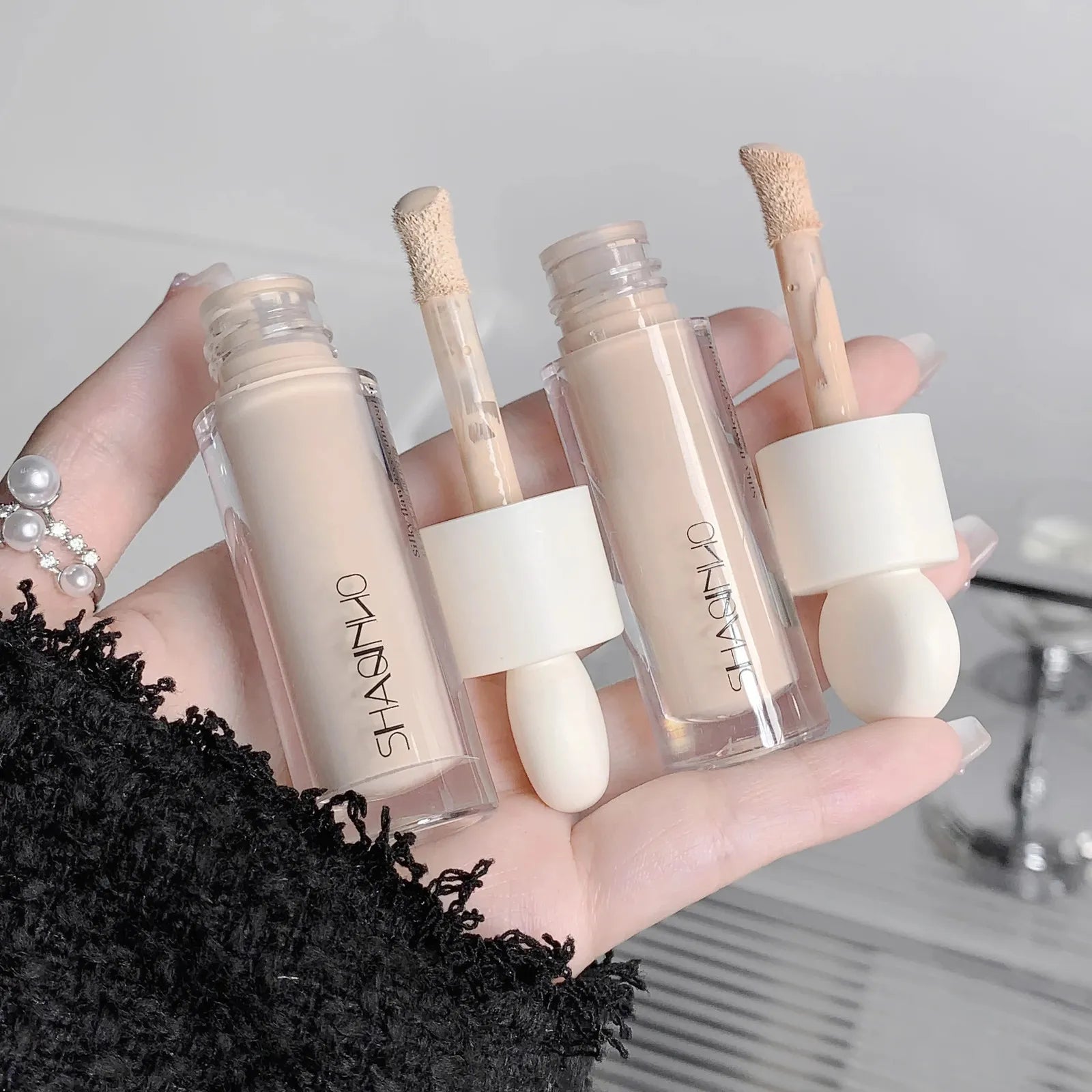 Three different shades of liquid concealer displayed side by side