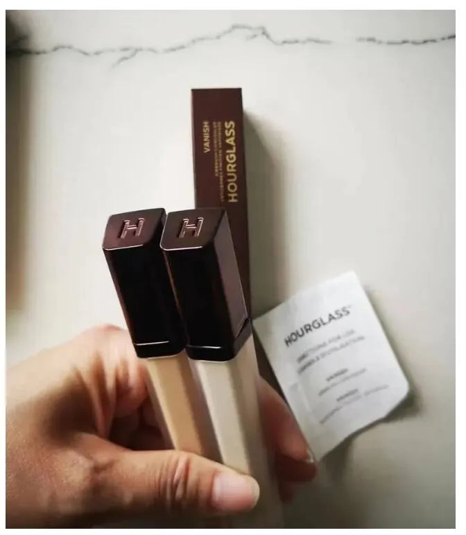 Hand applying concealer to facial area for coverage demonstration