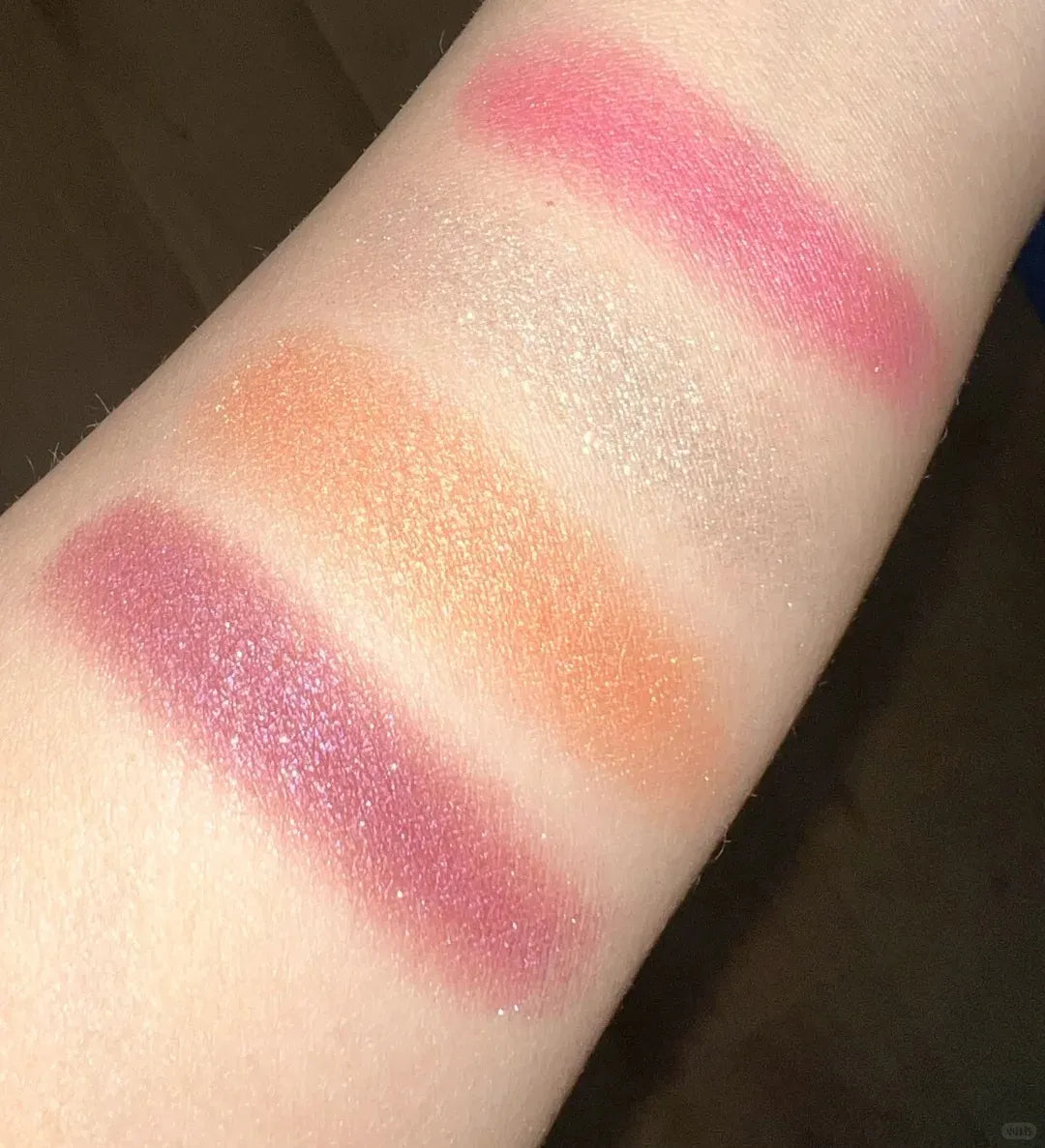 Makeup brush applying color from the palette to demonstrate texture