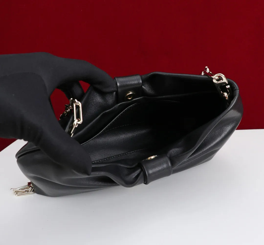 Front view of women's clutch bag with bow design in dark grey color