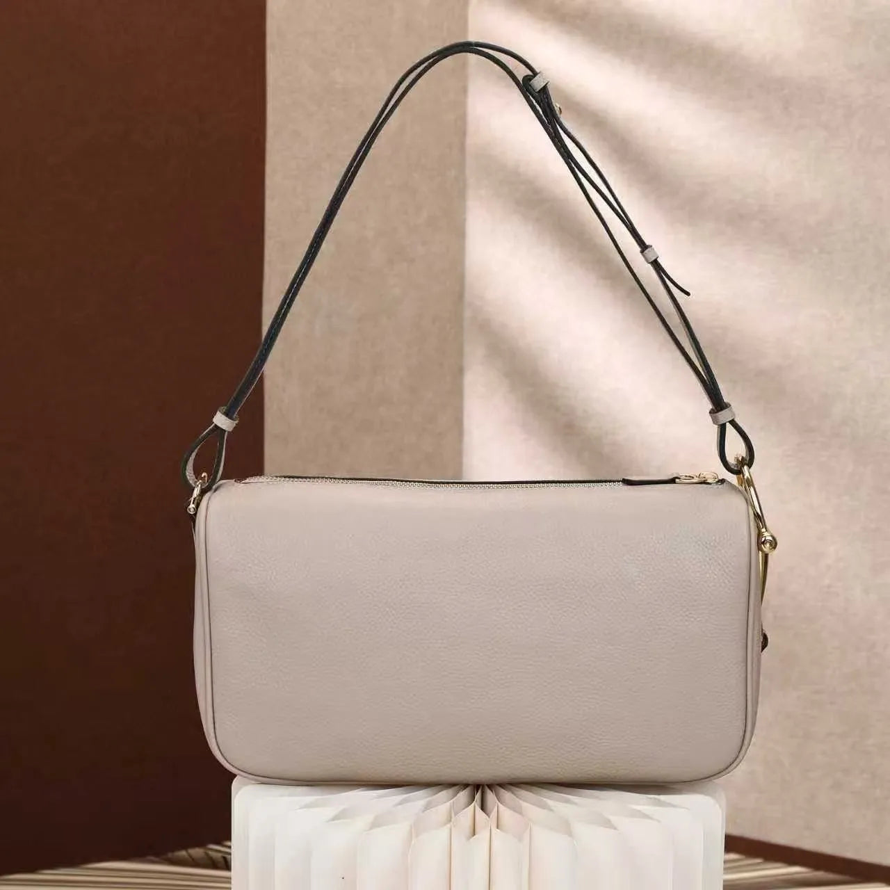 Side view of satchel bag displaying interior compartments and closure