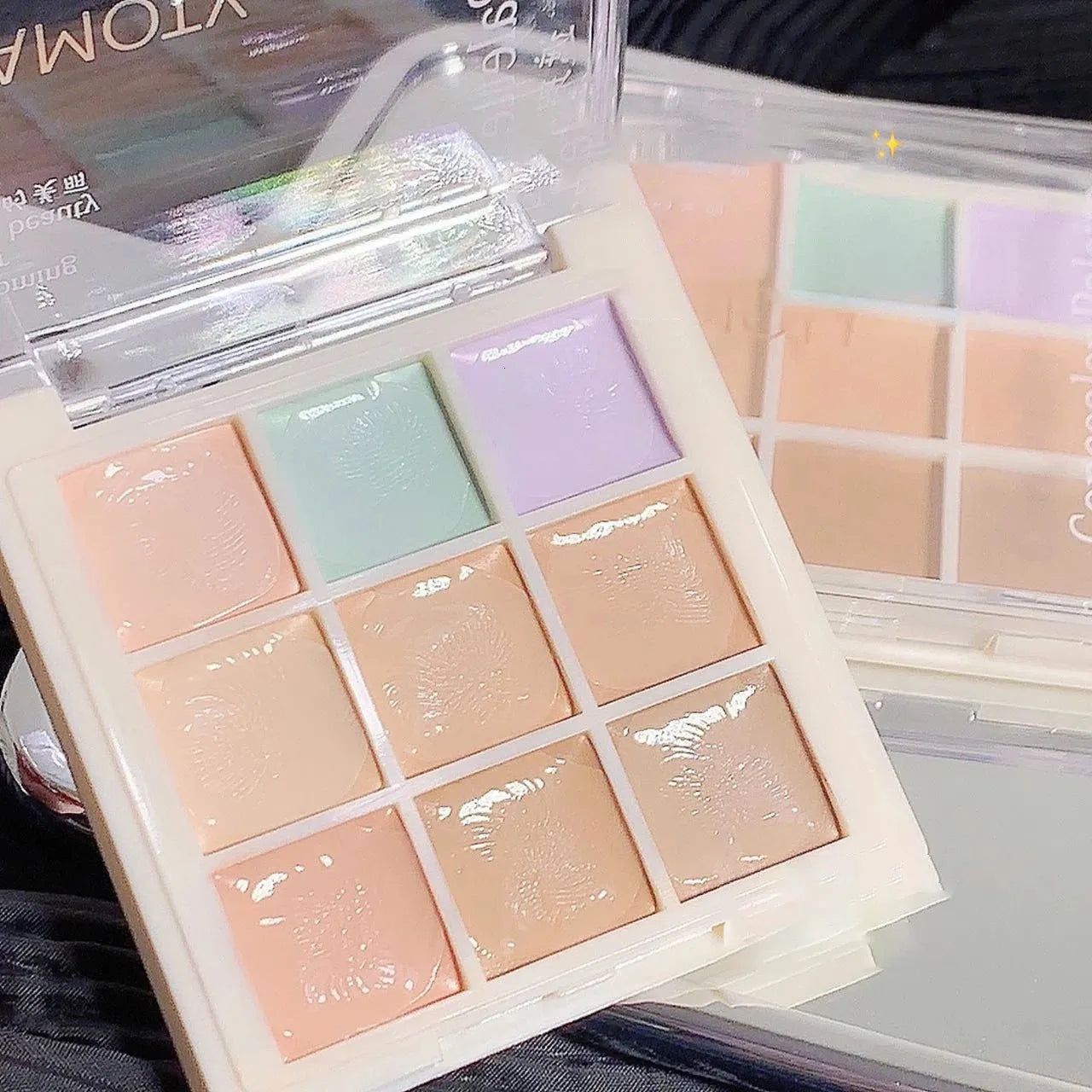 Open makeup palette showing nine different concealer shades arranged in a grid