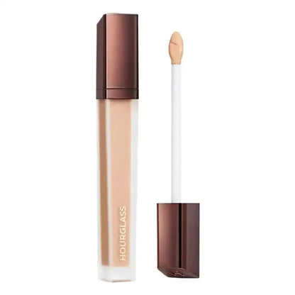 Liquid concealer bottle with applicator on a neutral background