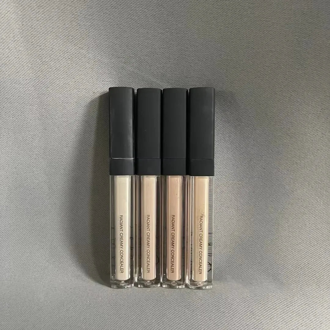 Creamy liquid concealer in a cosmetic container with applicator