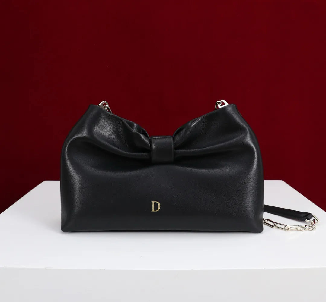 Side angle showing structured form and tote handles of evening bag
