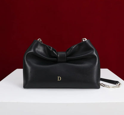 Side angle showing structured form and tote handles of evening bag