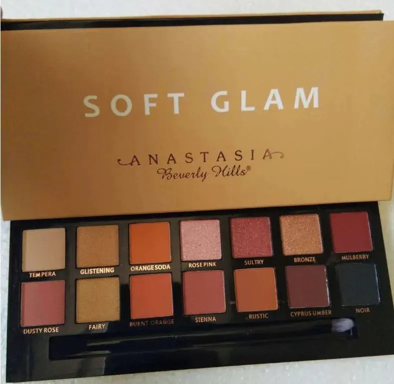 Open eyeshadow palette displaying matte and shimmer finishes in multicolor tones