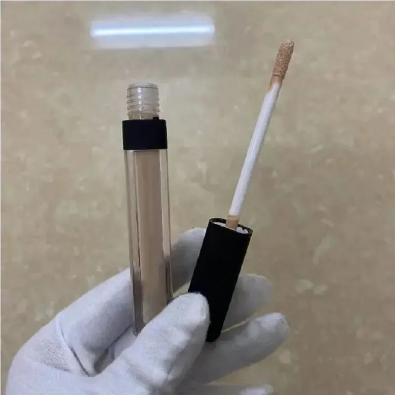 Four different shades of liquid concealer displayed in cosmetic containers