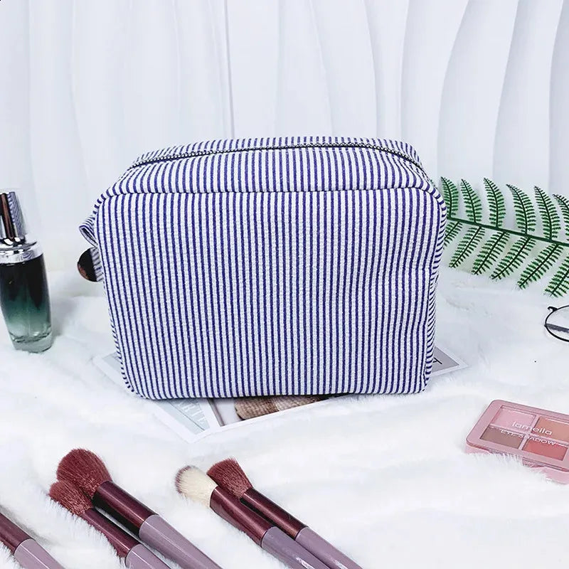 Close-up view of the zipper closure on the striped cosmetic bag