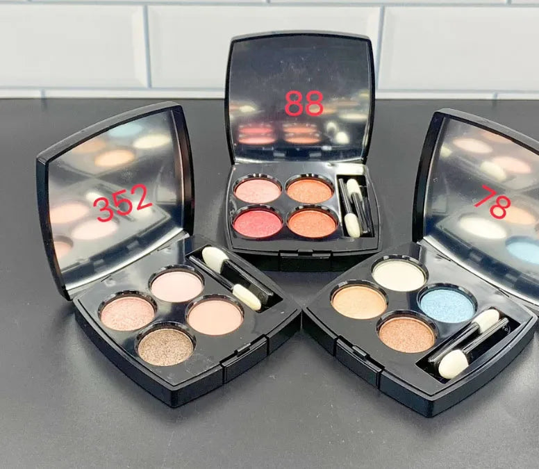 Front view of a 4-color eyeshadow palette with brush and glitter highlighter