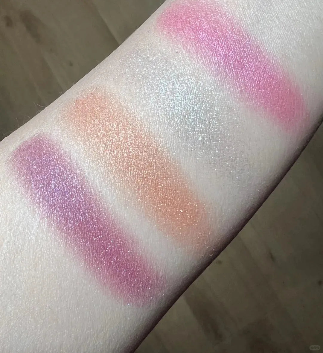 Makeup brush applying color from palette to hand