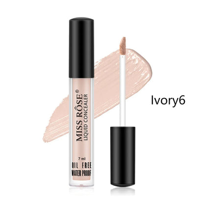 Hand holding concealer stick applying product to under-eye area