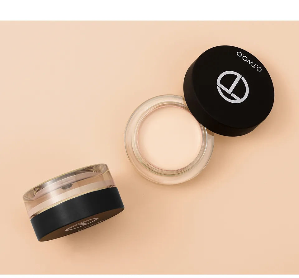 Four small containers of cream concealer arranged in a row