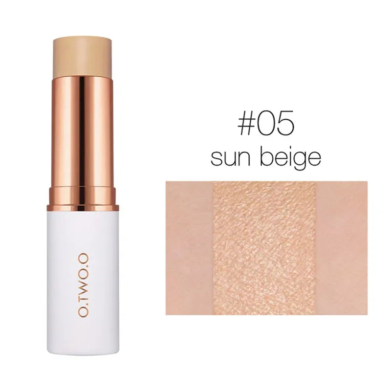 Hand holding a concealer stick with swatches of all six shades visible