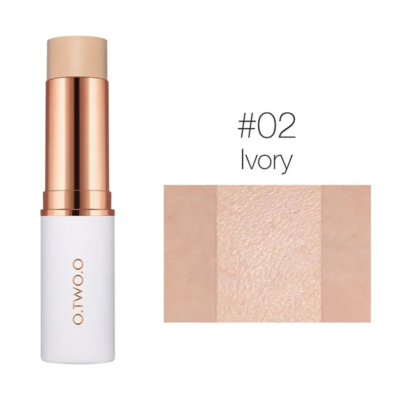 Hand holding a concealer stick with swatches of all six shades visible