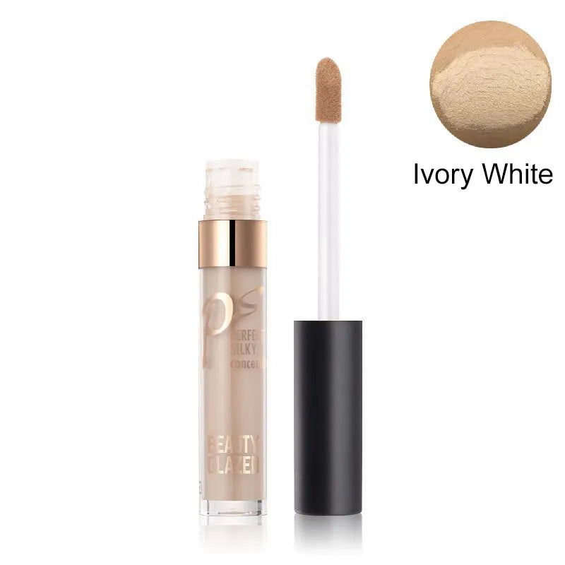 Close-up view of cream concealer texture with makeup brush nearby