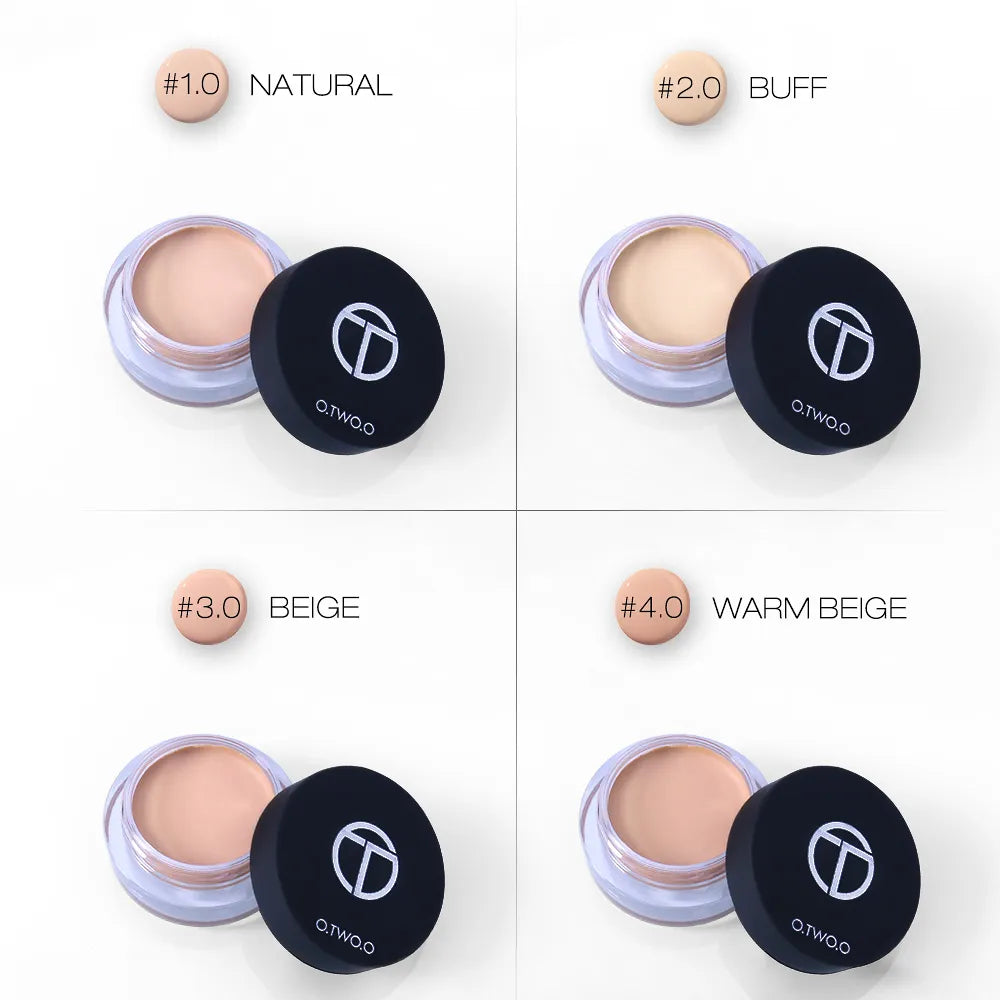 Hand holding a compact with multiple concealer shades visible