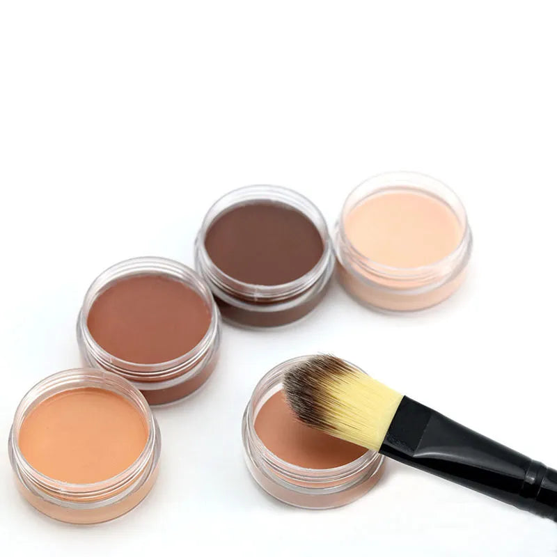 Close-up view of creamy makeup formula being applied to skin with brush