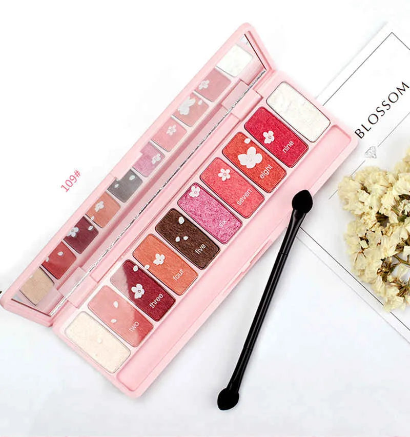 Eyeshadow palette with brush on neutral background