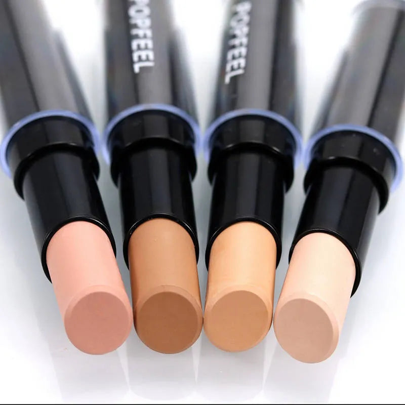 Hand holding concealer stick against skin demonstrating application