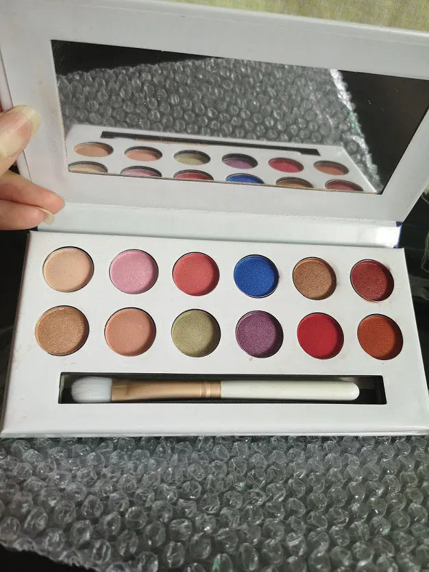 Open eyeshadow palette showing 12 shades in peach and nude colors