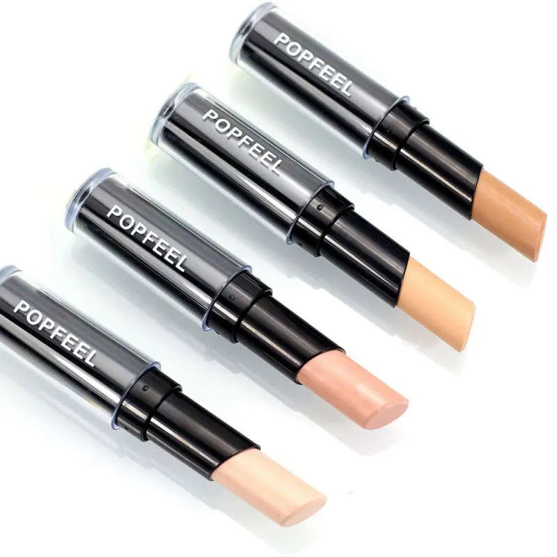 Hand holding concealer stick against skin demonstrating application