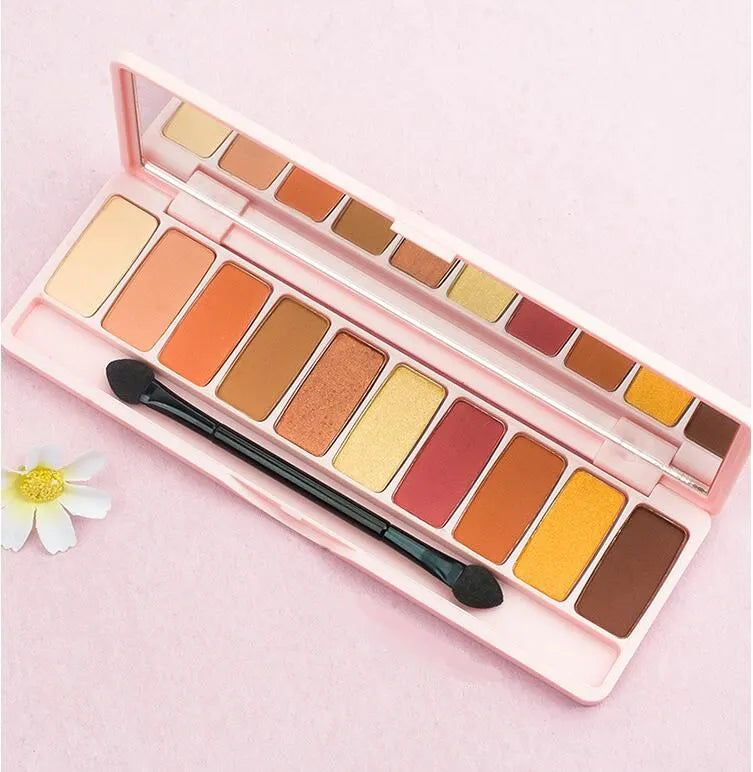 Eyeshadow palette with brush on neutral background